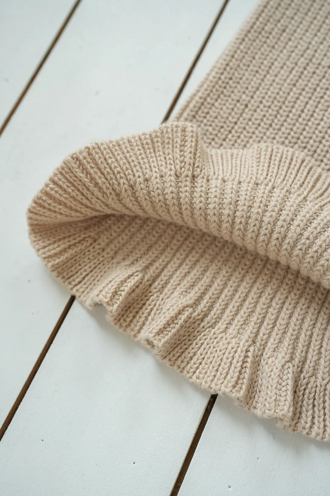 Beige cotton knit trousers with soft textured knit and ruffle hem detail