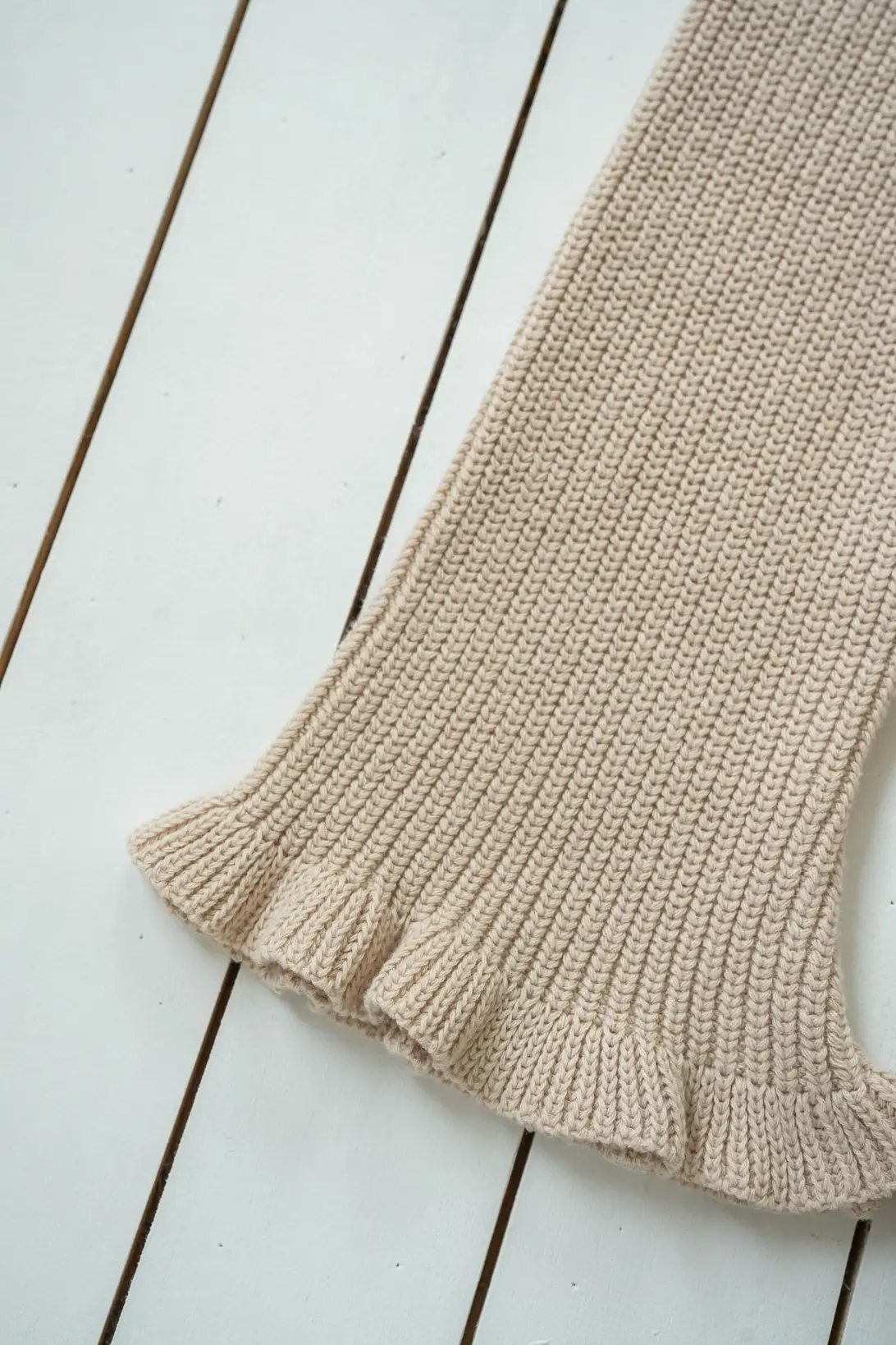 Beige cotton knit trousers with soft textured knit and ruffle hem detail