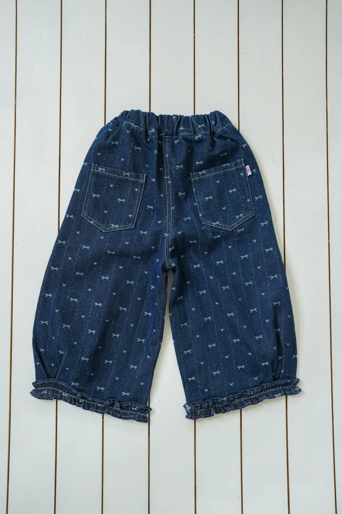image: Bow Denim Jeans for girls with delicate bow print and ruffled cuffs