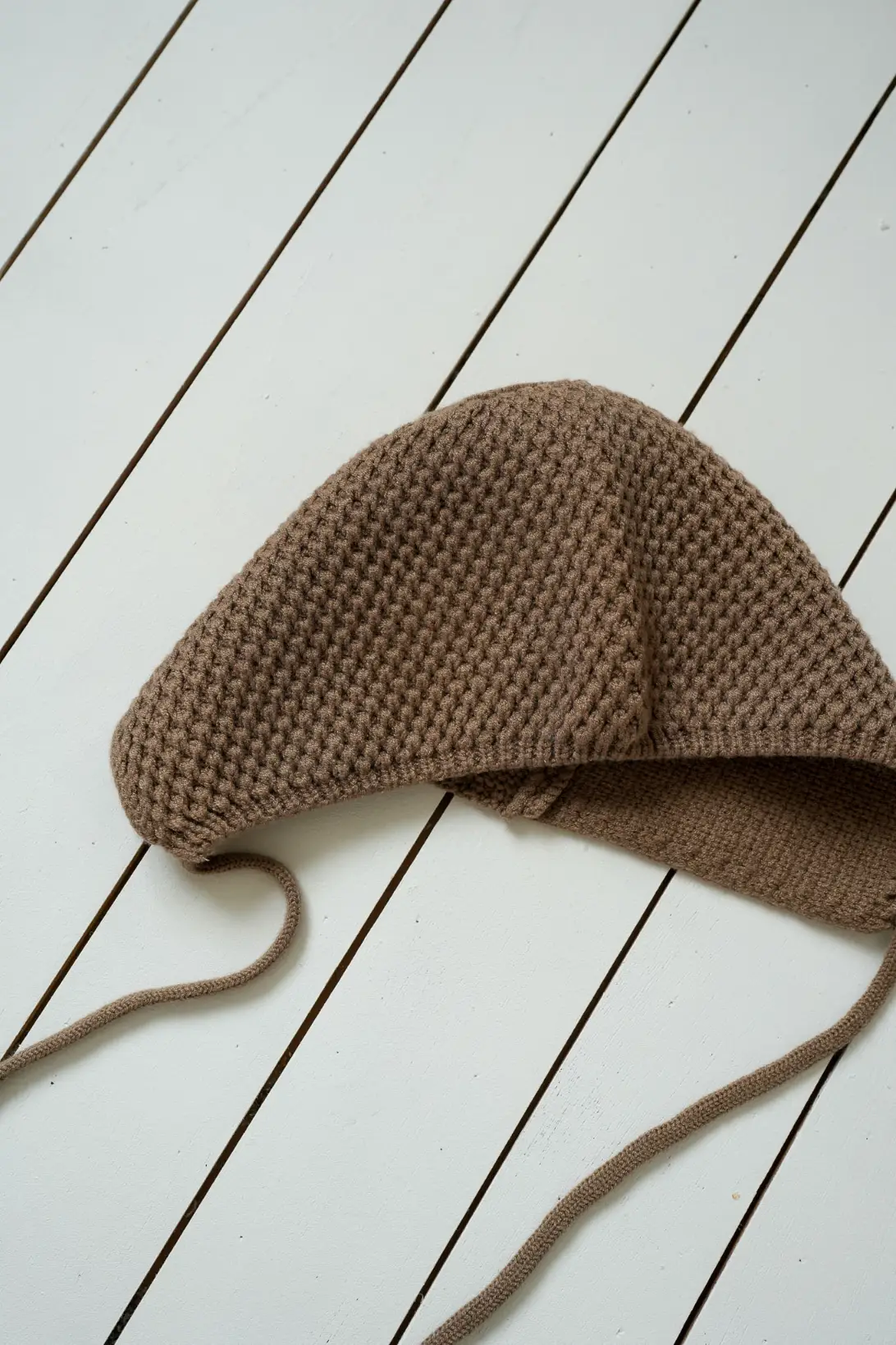 Soft textured knit detail of brown baby bonnet