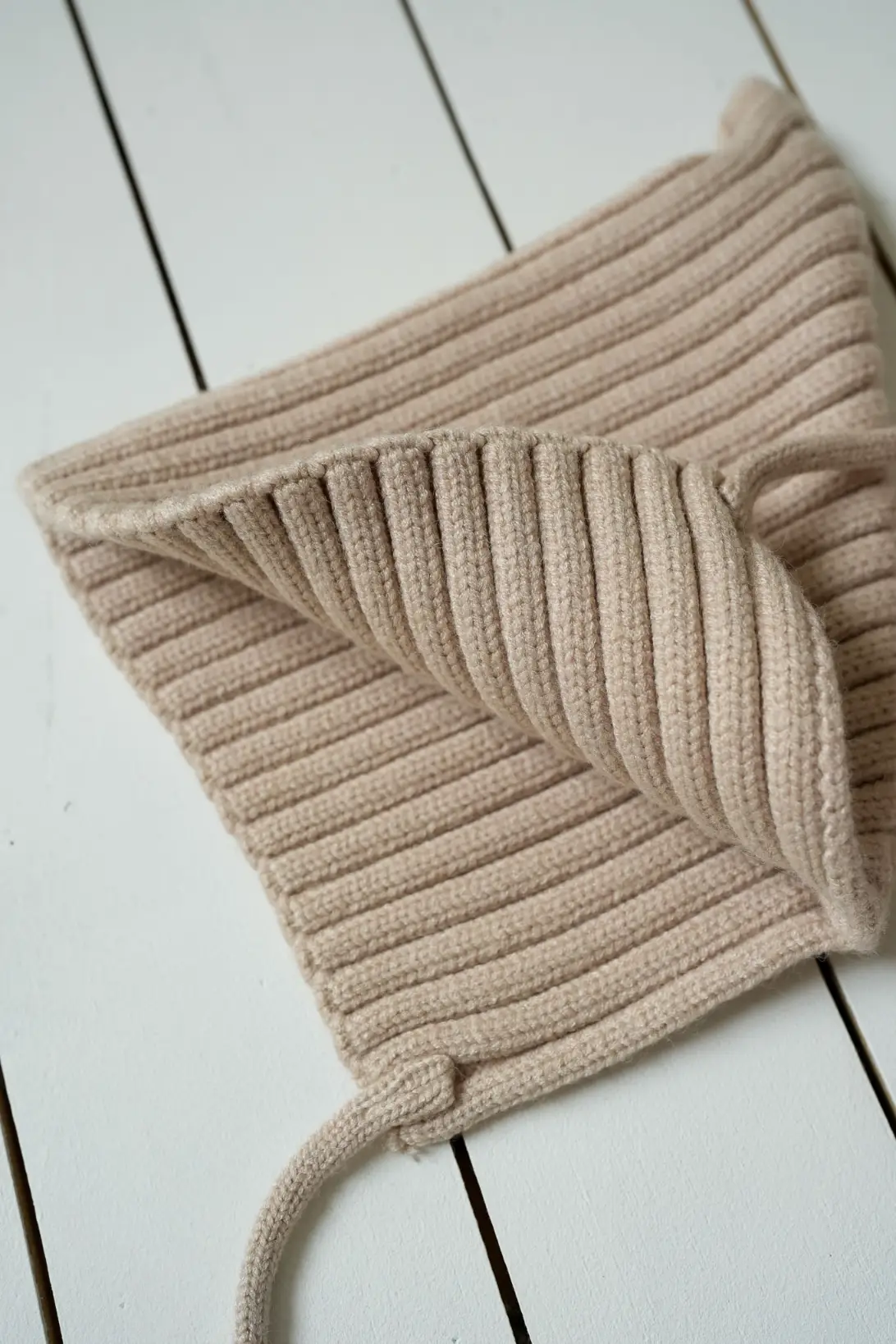 Soft ribbed knit texture of beige baby pixie bonnet