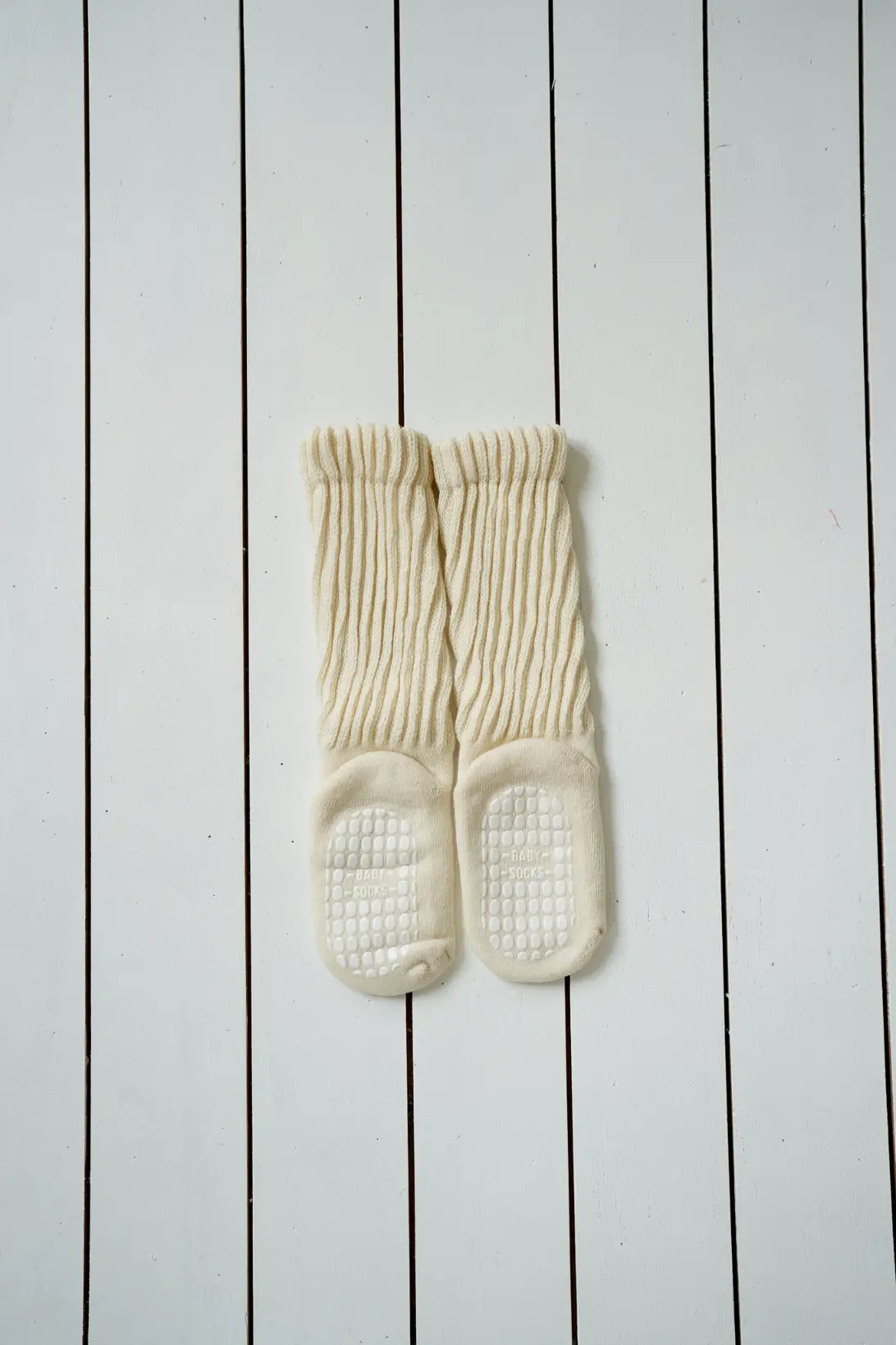 Cream knee high baby socks with ribbed texture