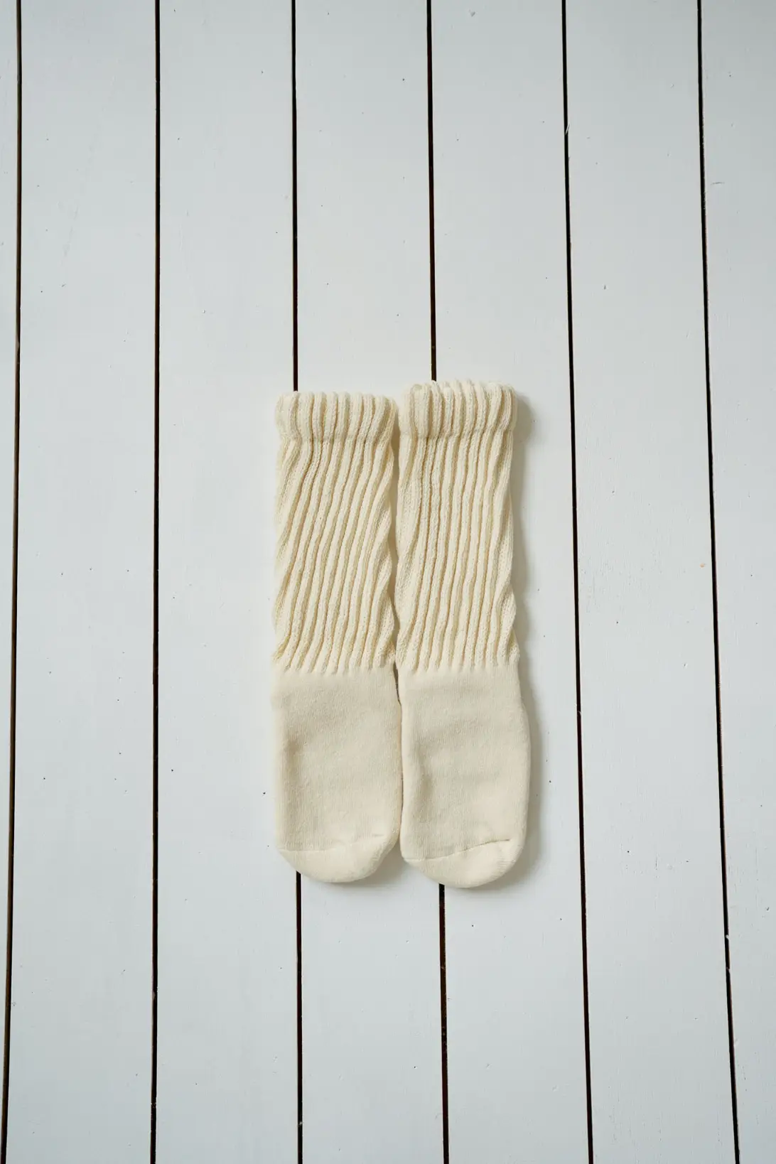 Cream knee high baby socks with ribbed texture